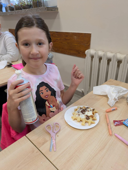 uczniowie jedzą przygotowane gofry