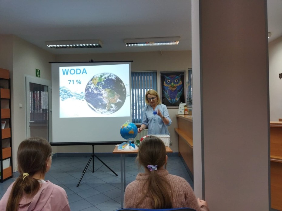Uczniowie z klasy 3c z wizytą w Bibliotece Pedagogicznej, słuchają pani opowiadającej jak należy dbać o naszą planetę