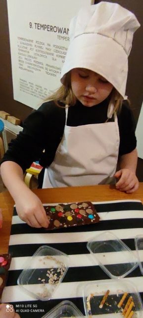 dziewczynka z klasy 1a wykonuje i ozdabia czekoladę