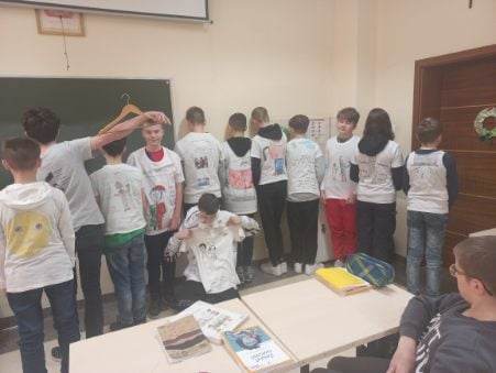 uczniowie prezentują zaprojektowane koszulki bohatera  bohatera - Ebenezera Scroogea